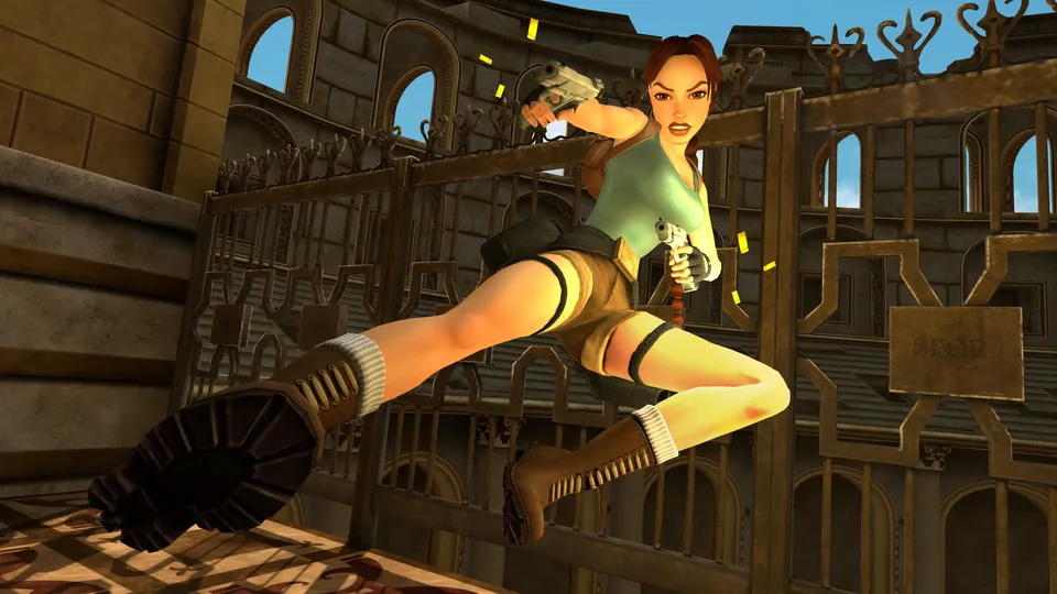 Lara Croft springt met twee pistolen langs een sierlijk ijzeren hek in een oud gebouw.